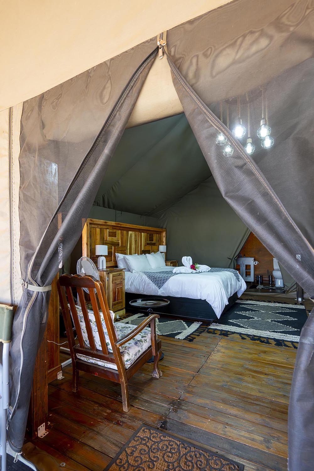 Blick durch den Zelteingang auf das Queen-Size-Bett
