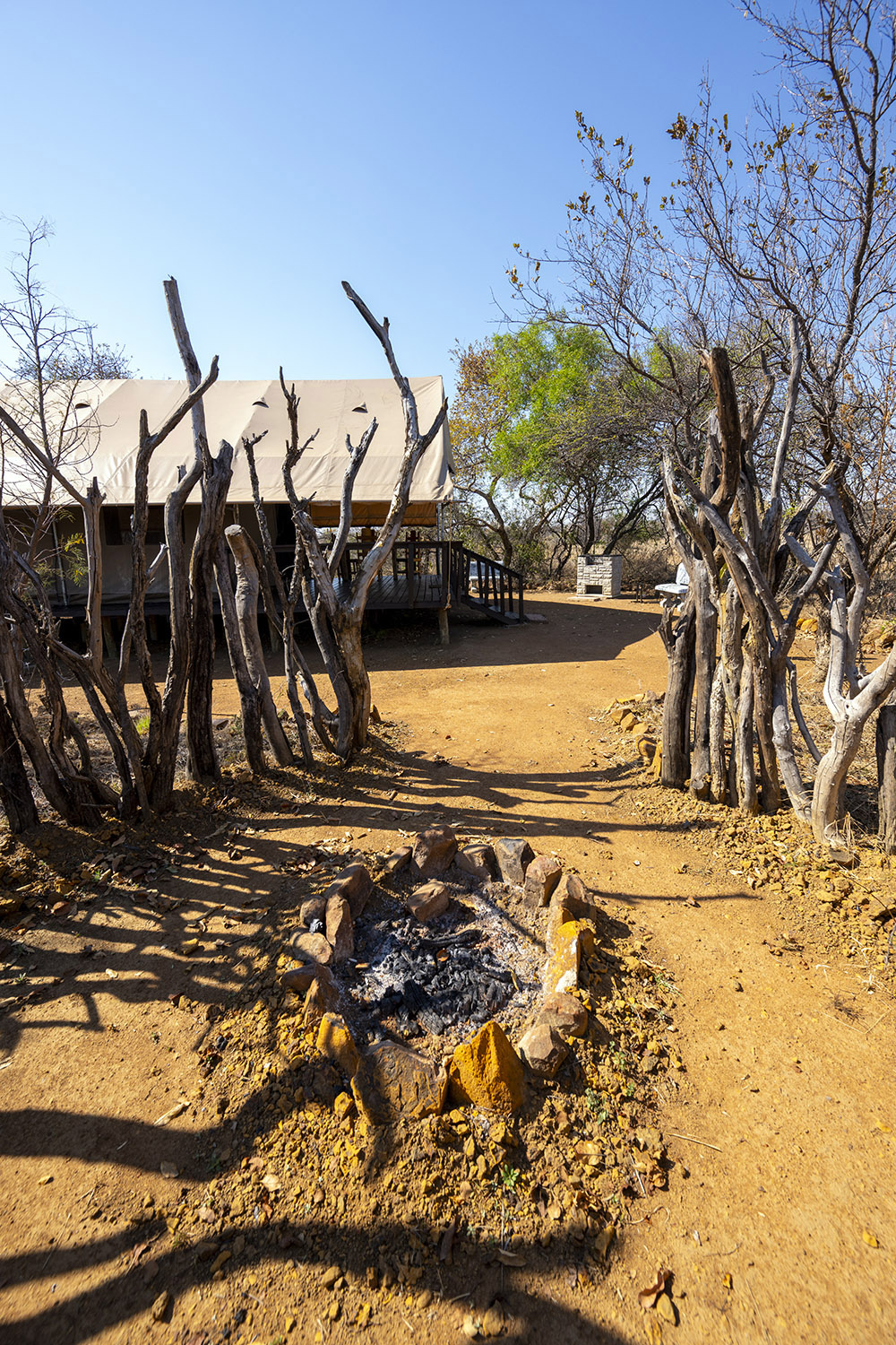 Feuerstelle der Boma mit dem Glamping-Zelt im Hintergrund